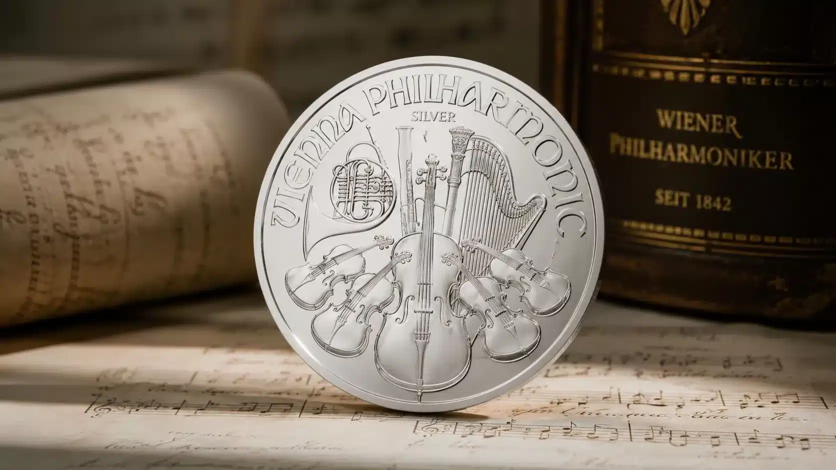 A close-up of a silver Vienna Philharmonic coin resting on vintage sheet music beside an old book.