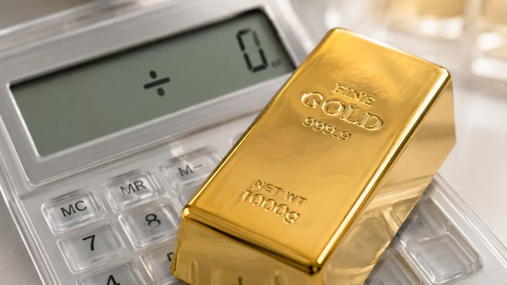 A solid gold bar with a weight of 1000g placed on top of a digital office calculator.